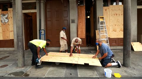 Workers board up windows in New Orleans' French Quarter before tropical storms Marco and Laura.