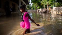A girl wades towards her flooded home the day after the passing of Tropical Storm Laura in Port-au-Prince, Haiti, Monday, Aug. 24, 2020. Laura battered the Dominican Republic and Haiti on it's way to the U.S. Gulf Coast, where forecaster fear it could become a major hurricane. (AP Photo/Dieu Nalio Chery)