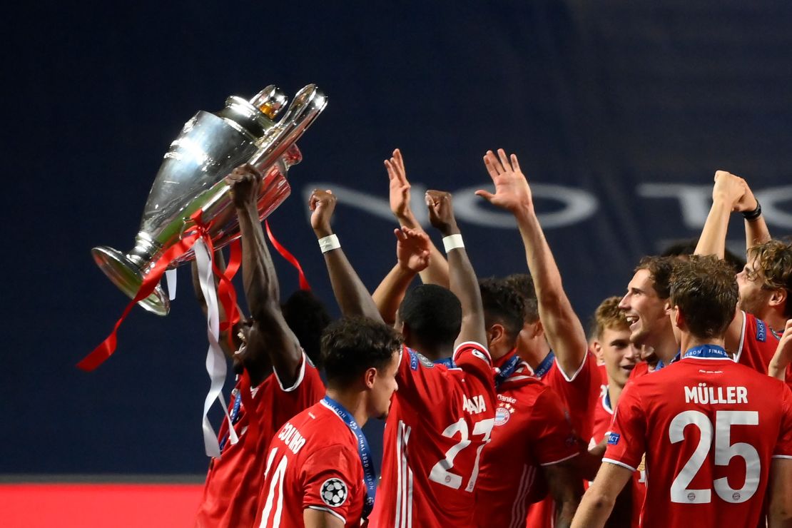 Alphonso Davies holds the Champions League the trophy aloft after beating PSG.