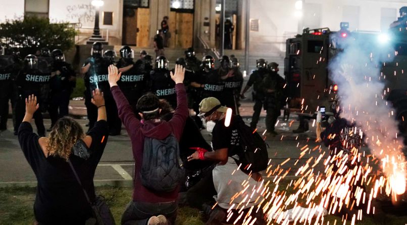 Police attempt to push back protesters outside the Kenosha County Courthouse on Monday, August 24.