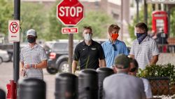 Pedestrians with face masks walk past diners in downtown Omaha, Neb., Friday, Aug. 7, 2020. (AP Photo/Nati Harnik)