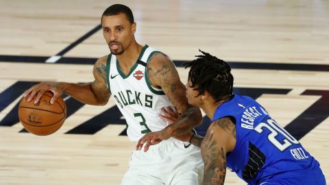 Bucks' George Hill (left) dribbles against the Orlando Magic in the NBA playoffs.