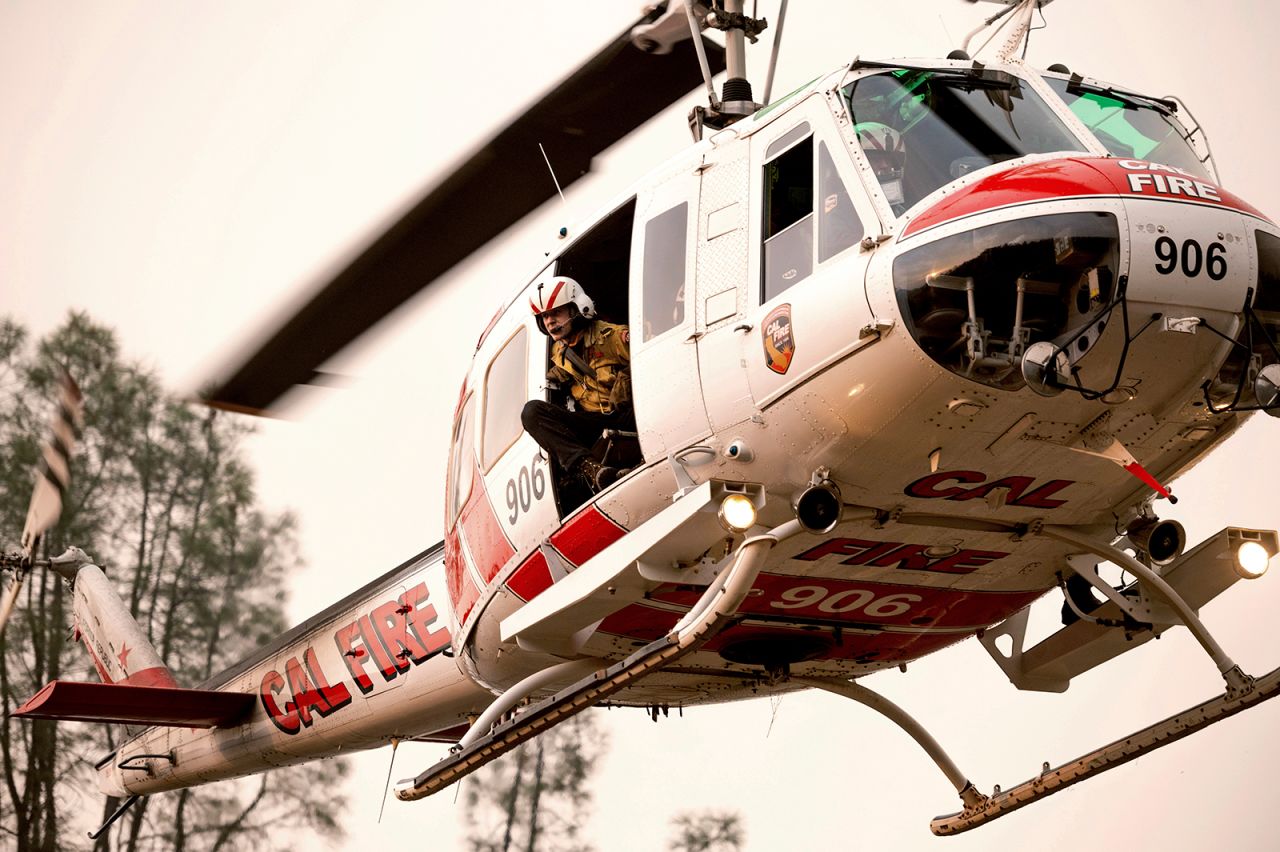A firefighter looks out from a helicopter while battling the LNU Lightning Complex fires in Lake County, California.