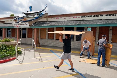 Nick Gaido, left, helps board up windows at his seafood restaurant in Galveston.