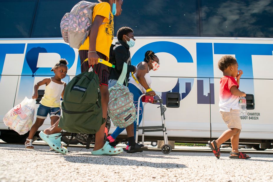 A family walks to a charter bus that would take them from Galveston Island to Austin.