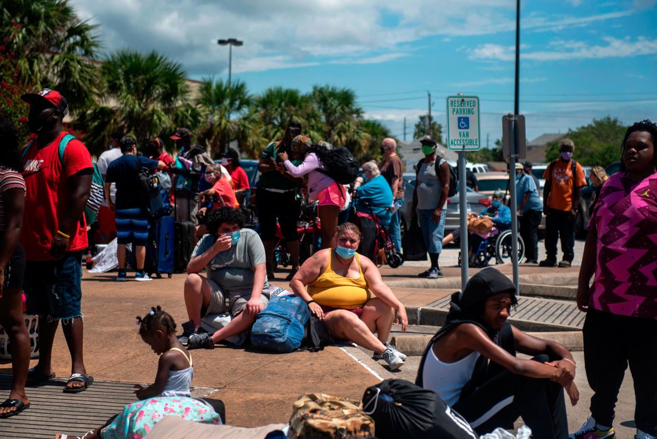 People wait to board a bus to leave Galveston.
