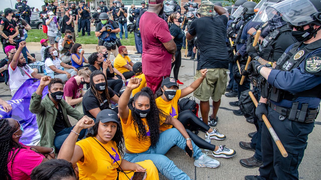 A group of demonstrators sat down in front of police during a march for Breonna Taylor in Louisville, Kentucky.