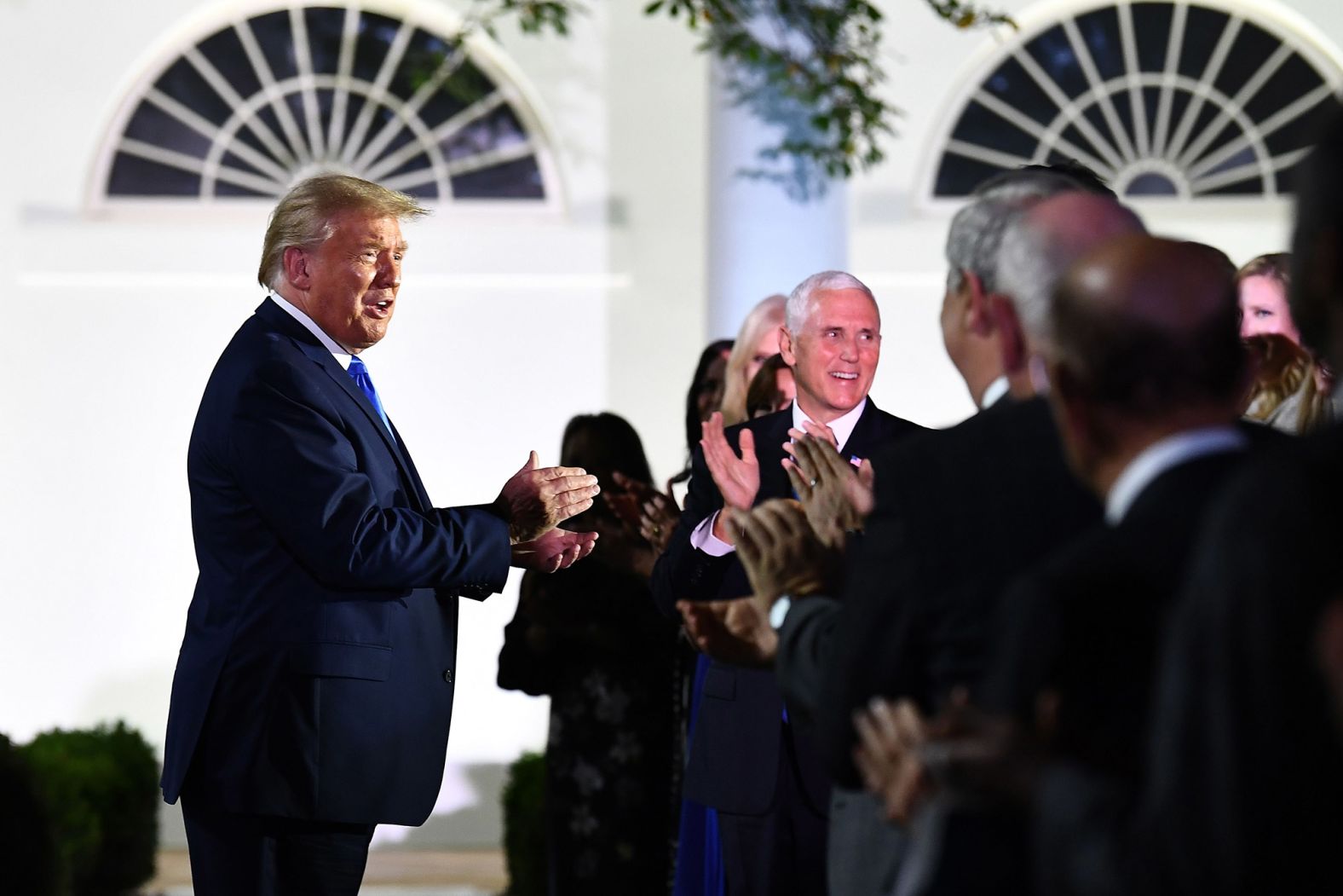 President Trump, alongside Vice President Mike Pence, arrives at the Rose Garden for his wife's speech.