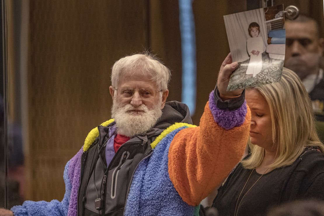 John Milne holds a photograph of his son, Sayyad Milne, who was killed in the attacks, during his victim impact statement in Christchurch, New Zealand, on August 26, 2020. 