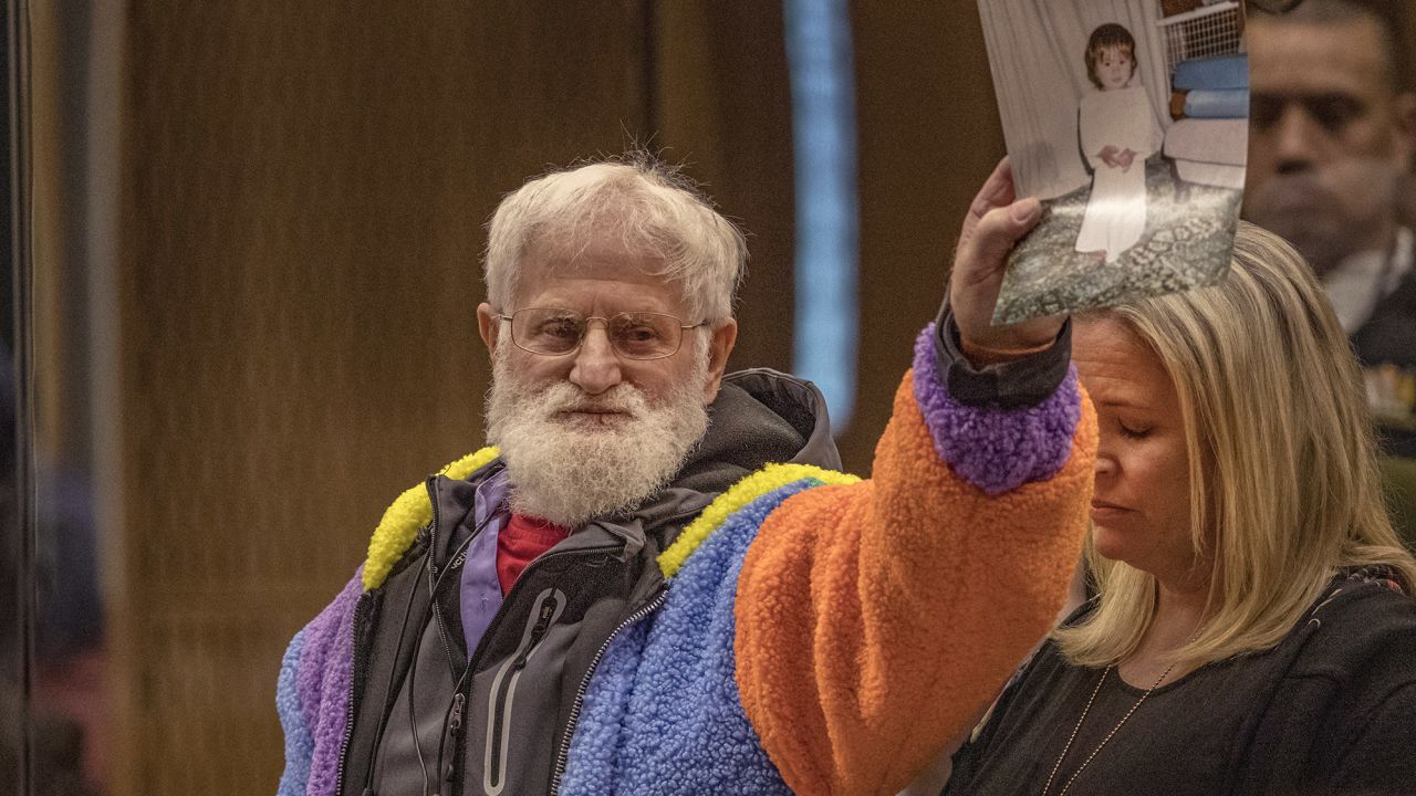 John Milne holds a photograph of his son, Sayyad Milne, who was killed in the attacks, during his victim impact statement in Christchurch, New Zealand, on August 26, 2020.
