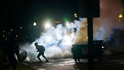 A protester moves away from a smoke canister Tuesday, Aug. 25, 2020 in Kenosha, Wis. Anger over the Sunday shooting of Jacob Blake, a Black man, by police spilled into the streets for a third night. (AP Photo/Morry Gash)