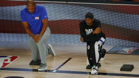 Rivers kneels with Lou Williams during the National Anthem before the start of a game against the Dallas Mavericks.