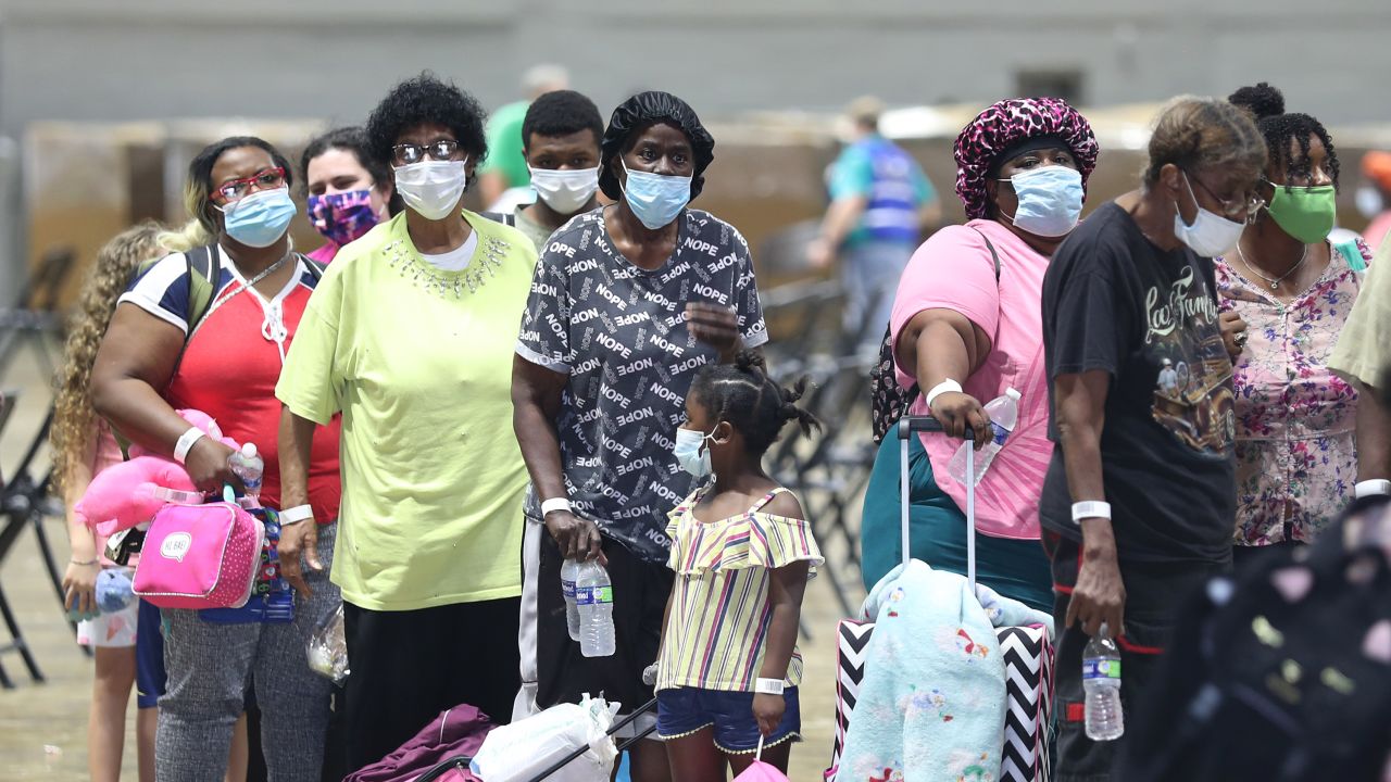 People stand in line as they prepare to board a bus as they are evacuated by government officials in Lake Charles, Louisiana, on Tuesday.