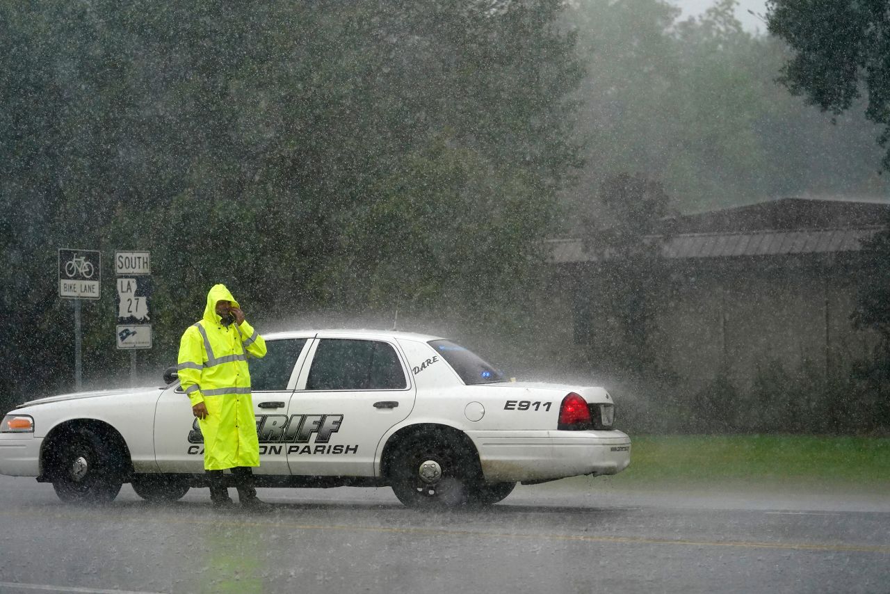 A sheriff's deputy wipes his face while manning a roadblock in Lake Charles on August 26.