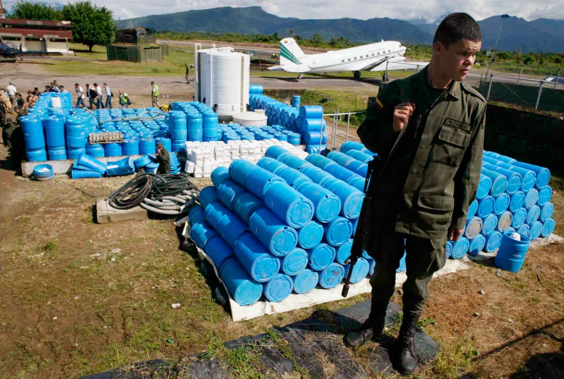 A police officer stand in front of herbicide containers at an anti-narcotic police base in Villa Garzon, near the southern Colombia's border with Ecuador, on Dec. 15, 2006.  