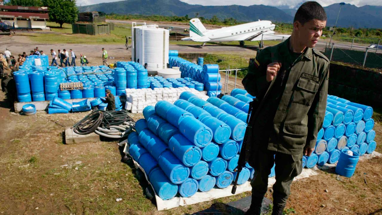 A police officer stand in front of herbicide containers at an anti-narcotic police base in Villa Garzon, near the southern Colombia's border with Ecuador, on Dec. 15, 2006.