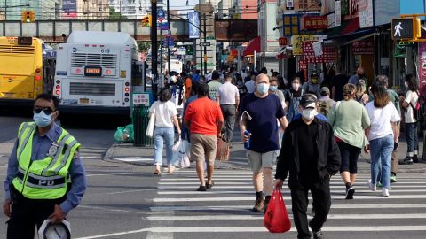 People wearing face masks cross a street amid the coronavirus outbreak on June 10, 2020 in New York City. 