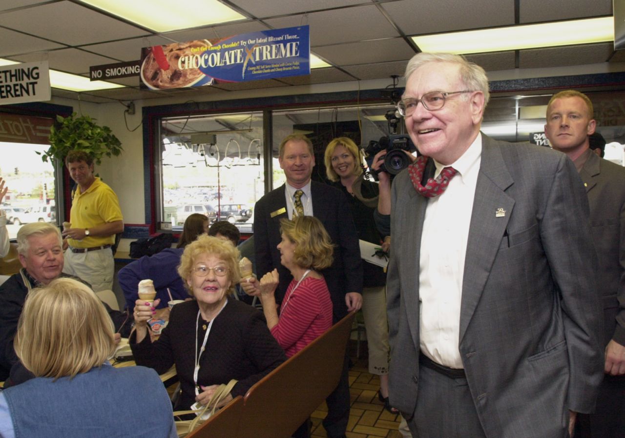 Buffett arrives at an Omaha Dairy Queen to autograph books and chat with Berkshire Hathaway shareholders in 2002. Many people were in Omaha for Berkshire Hathaway's annual shareholders meeting, which has been described as "the Woodstock of Capitalism."