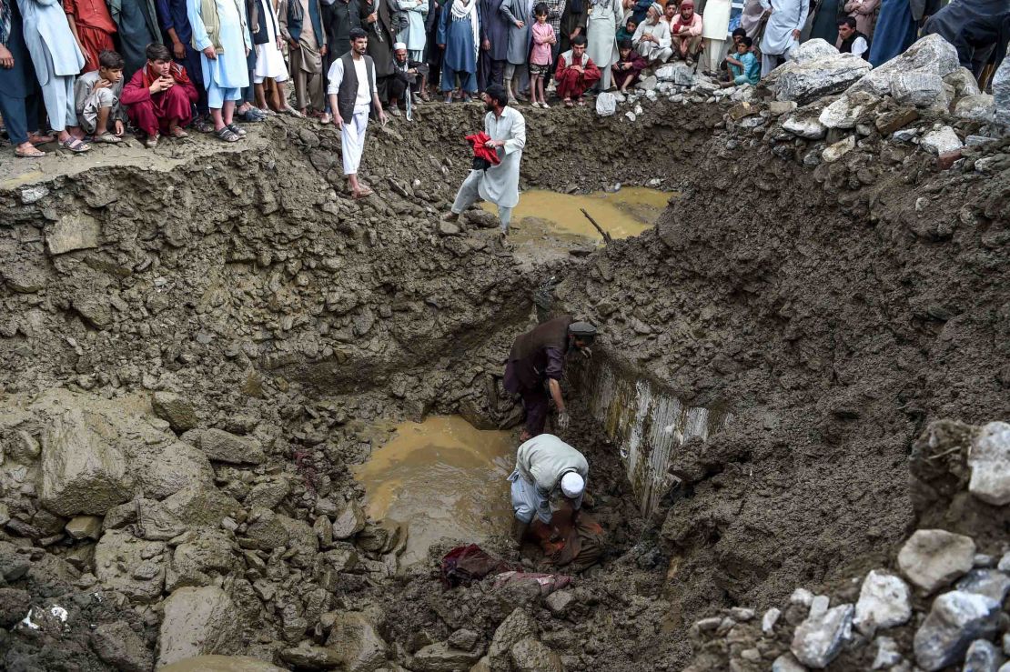 Villagers and rescuers search for bodies among debris after a flash floods in Parwan province, on August 26, 2020.
