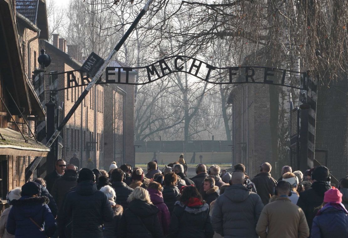 Visitors enter through the main gate of the Auschwitz Nazi death camp, which is now a memorial and museum.