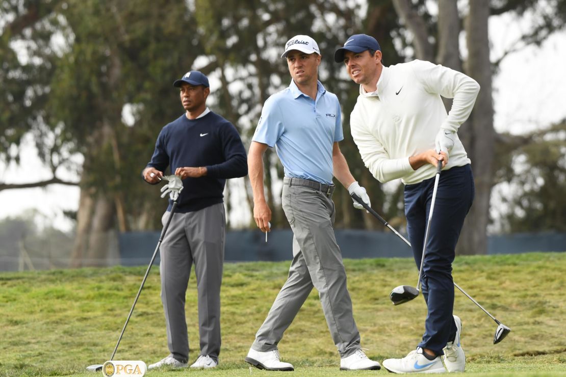 McIlroy reacts to his shot from the 12th tee at the 2020 PGA Championship in San Francisco as Thomas and Woods watch on.