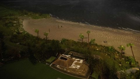 The remnants of a flattened building lie near a beach as the eye wall of Laura passes over Lake Charles, Louisiana. 