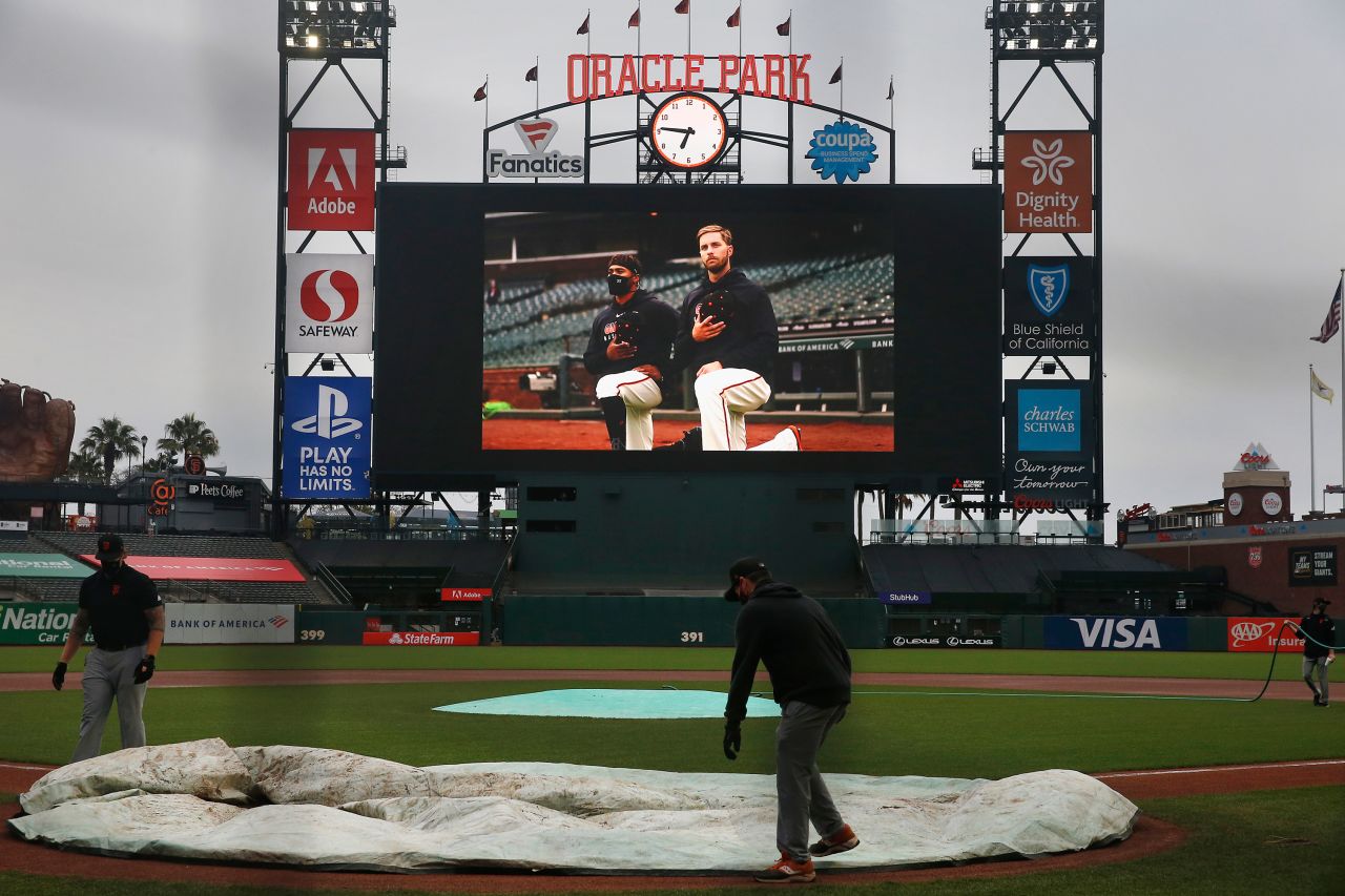 A grounds crew covers the field at San Francisco's Oracle Park after a Major League Baseball game was postponed on August 26.