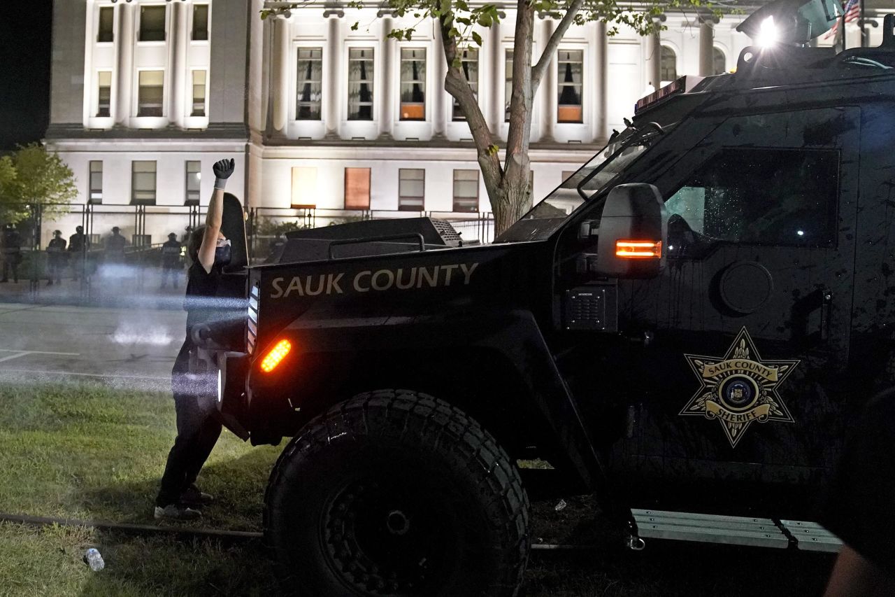 A protester obstructs an armored vehicle outside the Kenosha County Courthouse.
