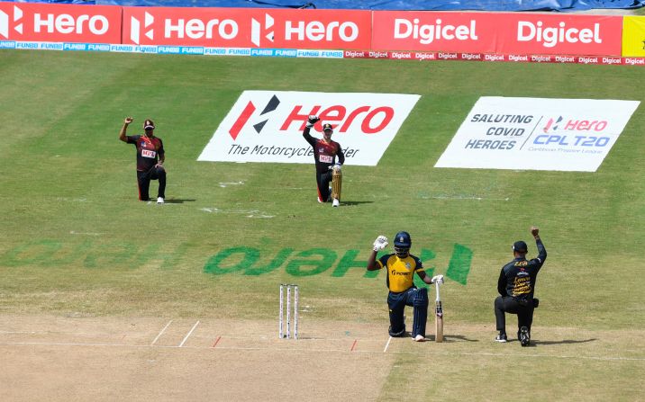 Members of the Trinbago Knight Riders kneel before a cricket match in Port of Spain, Trinidad and Tobago.