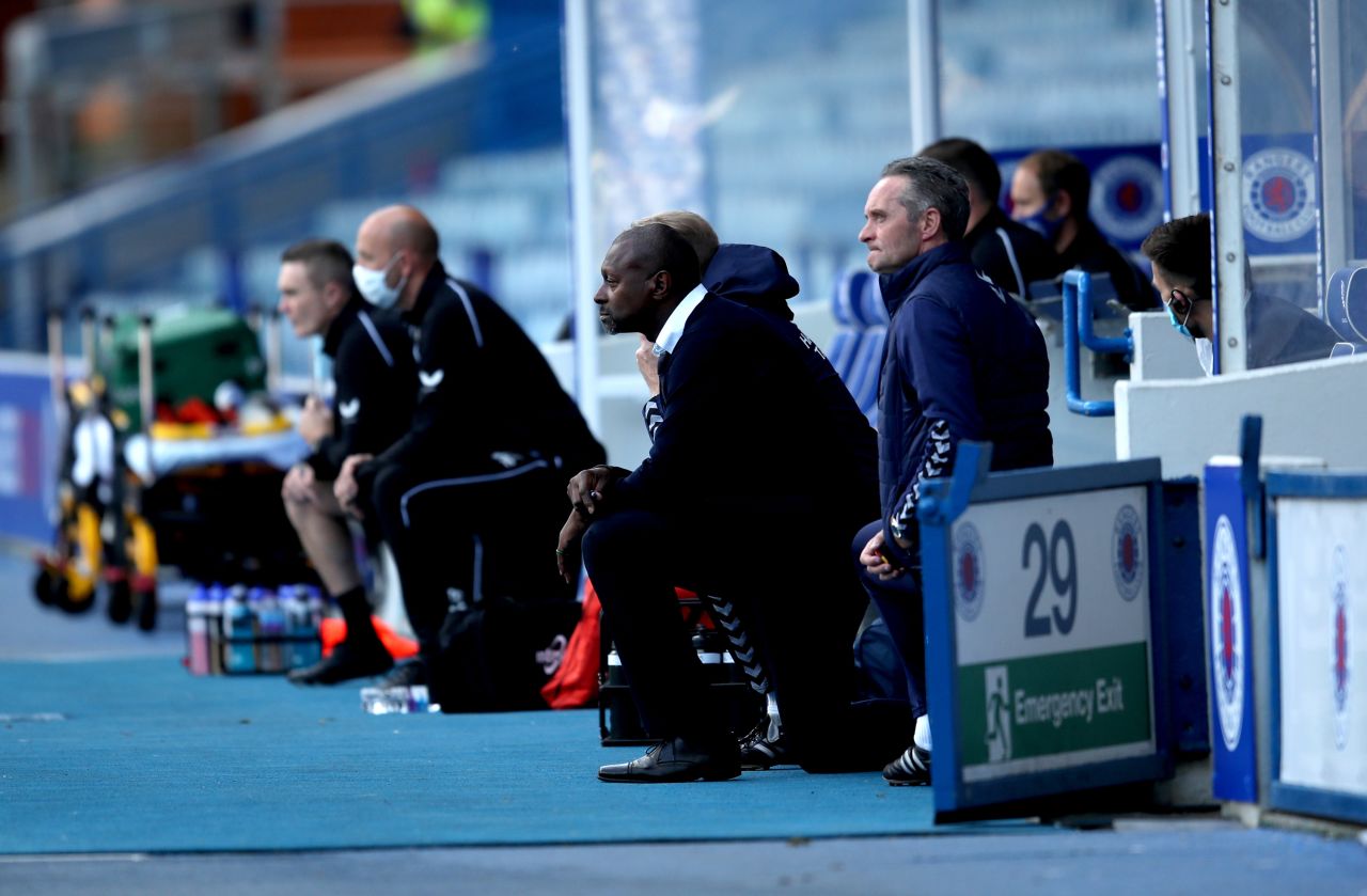 Kilmarnock manager Alex Dyer, second from right, takes a knee before a soccer match in Glasgow, Scotland.