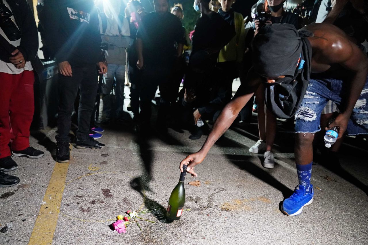 A protester places a bottle at the scene where <a href="https://www.cnn.com/2020/08/26/us/kenosha-wisconsin-wednesday-shooting/index.html" target="_blank">a person was fatally shot during demonstrations</a> the night before.