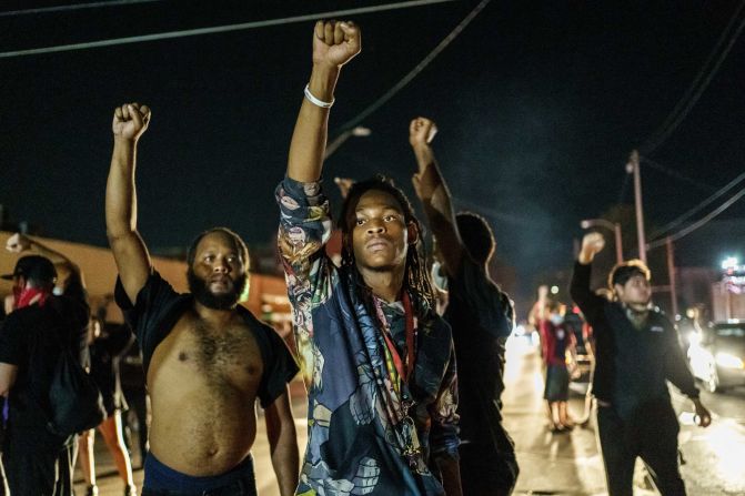 Protesters raise their fists during a demonstration in Kenosha on August 26.