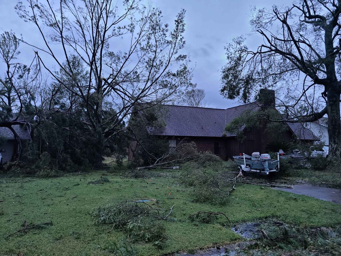 Downed trees litter the yard of a home in Sulphur, Louisiana.
