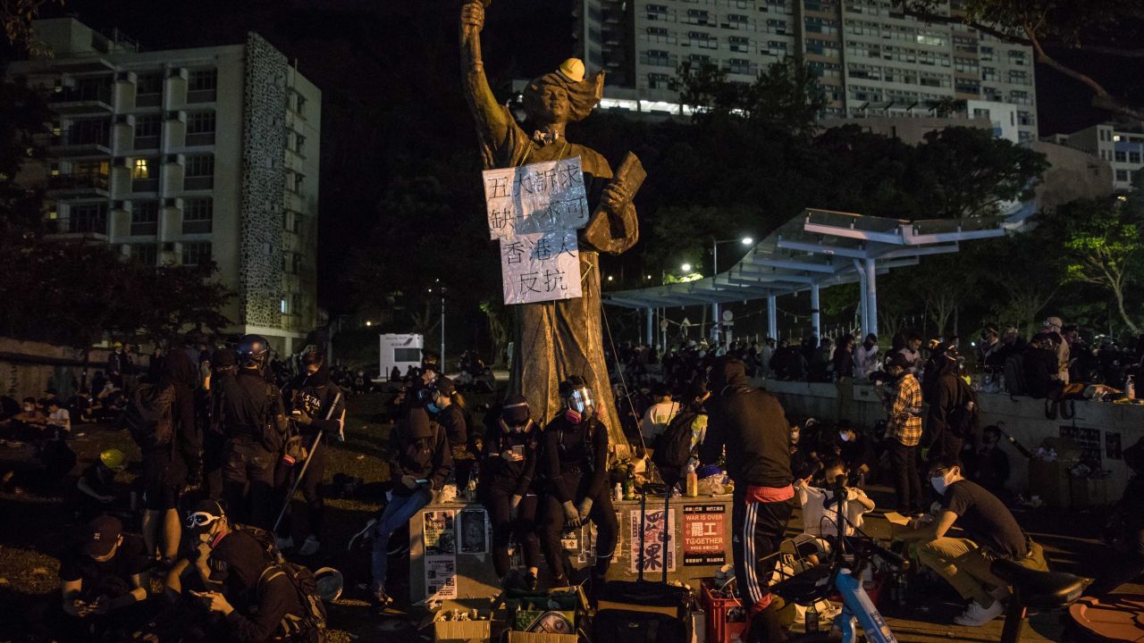 Protesters sit next to a Goddess of Democracy statue at the Chinese University of Hong Kong (CUHK) in Hong Kong on November 12, 2019. 
