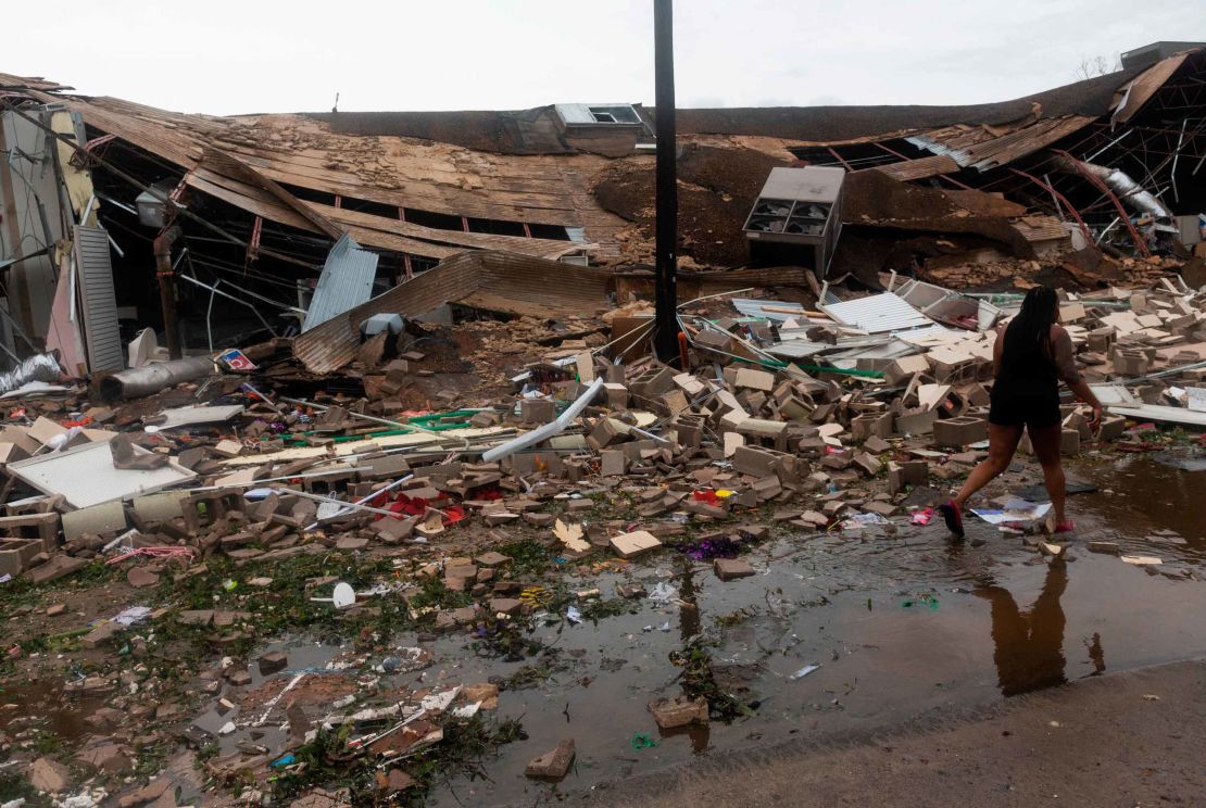 People walk past a destroyed building in Lake Charles.
