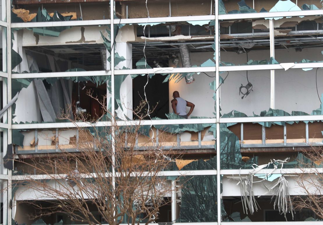 A person is seen through the blown out windows of the Capitol One Bank Tower in the downtown area of Lake Charles on Thursday.