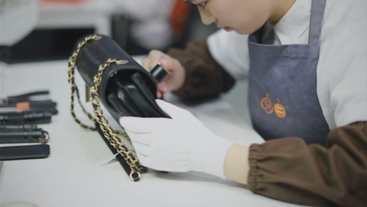 A still from a promotional video by luxury resale platform, Zhi Er, shows an authenticator examining a consigned handbag.