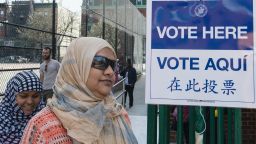 Two women with Muslim headscarves walk past a voting sign on April 19, 2016 in Brooklyn, New York.