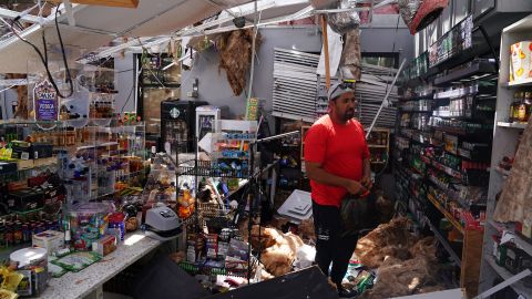 Ahmed Nawaz looks through the damage to his store after Hurricane Laura passed through Lake Charles, Louisiana.