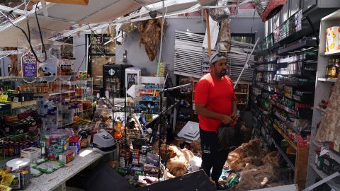 Ahmed Nawaz looks through the damage to his store after Hurricane Laura passed through Lake Charles, Louisiana.