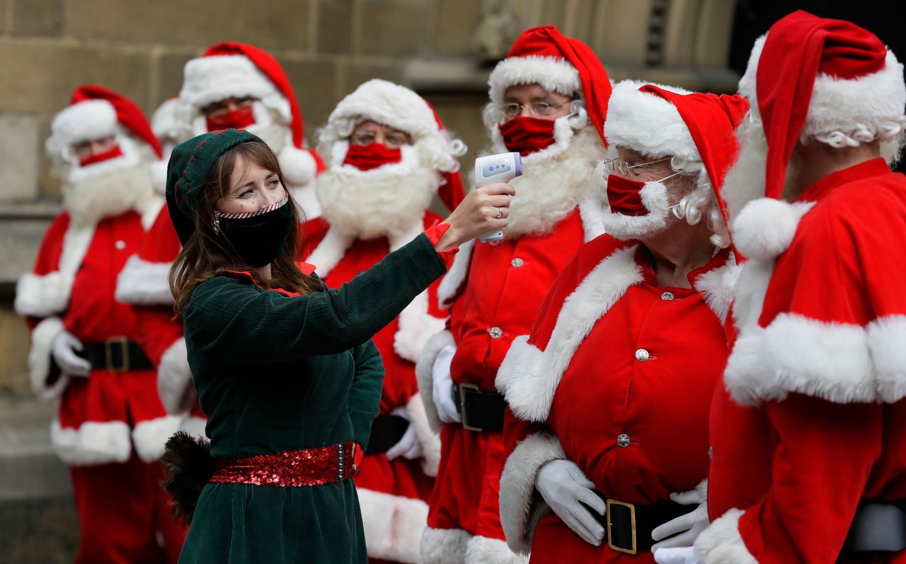 Men have their temperature taken as they attend a Santa school at the Southwark Cathedral in London on August 24.