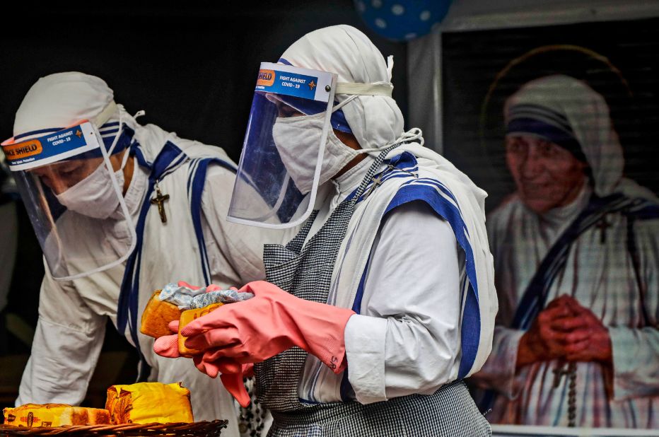 Nuns of the Missionaries of Charity, the order founded by Mother Teresa, wear masks and face shields as they distribute food to the poor and homeless in Kolkata, India, on August 26.