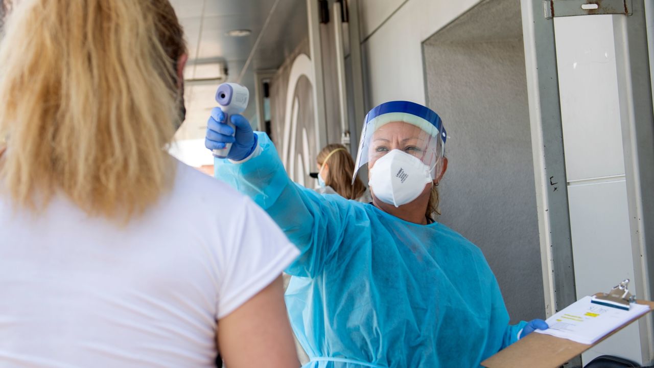 A health worker checks the temperature of a patient before she gets a coronavirus test. More than 5.8 million people have been infected with Covid-19 in the US, research from Johns Hopkins University shows.