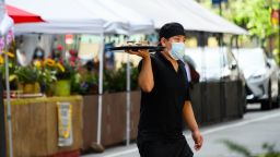 A server wears a face mask while serving food at a restaurant in Korea Town as the city continues Phase 4 of re-opening following restrictions imposed to slow the spread of coronavirus on July 26, 2020 in New York City. The fourth phase allows outdoor arts and entertainment, sporting events without fans and media production. (Photo by Noam Galai/Getty Images)