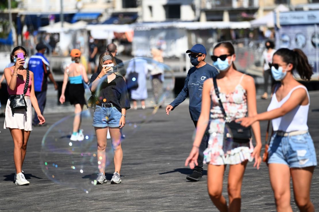 People wearing face masks stroll in the old harbour of Marseille on Wednesday.