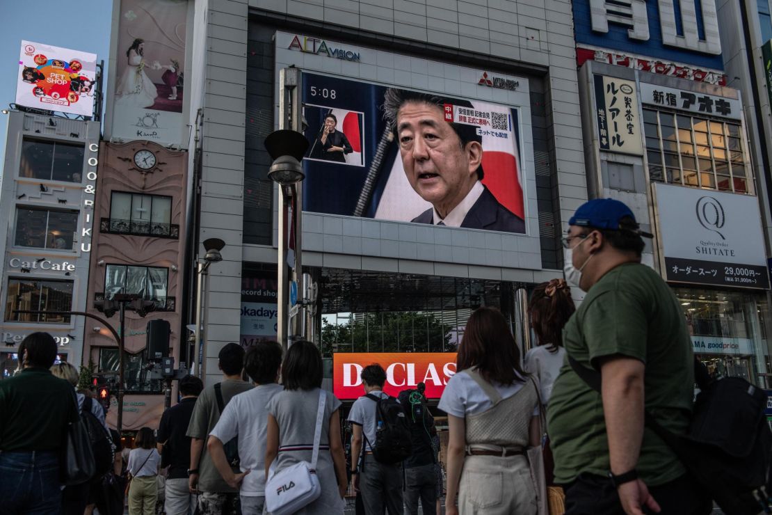 People watch Abe's press conference in Tokyo on Friday. 