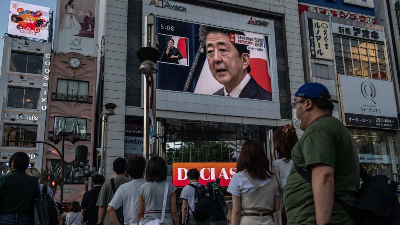 People watch Abe's press conference in Tokyo on Friday.