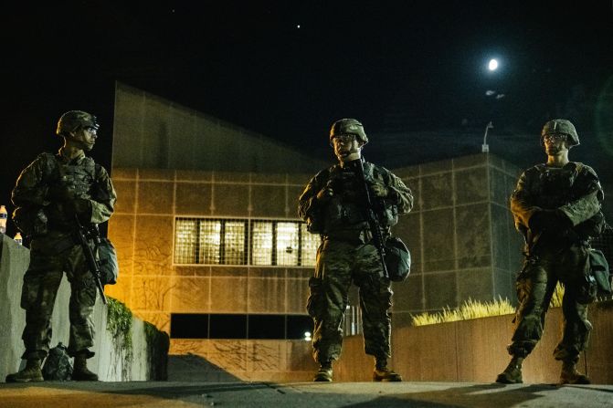 Members of the National Guard stand inside a fenced area surrounding government buildings on August 27.