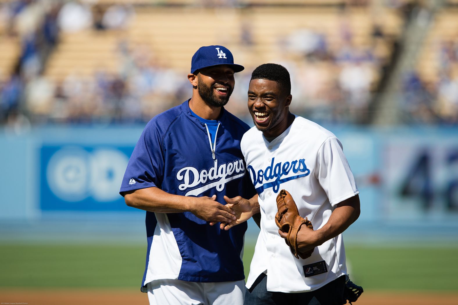 Boseman laughs with baseball star Matt Kemp after throwing out the first pitch at a Los Angeles Dodgers game in 2013.