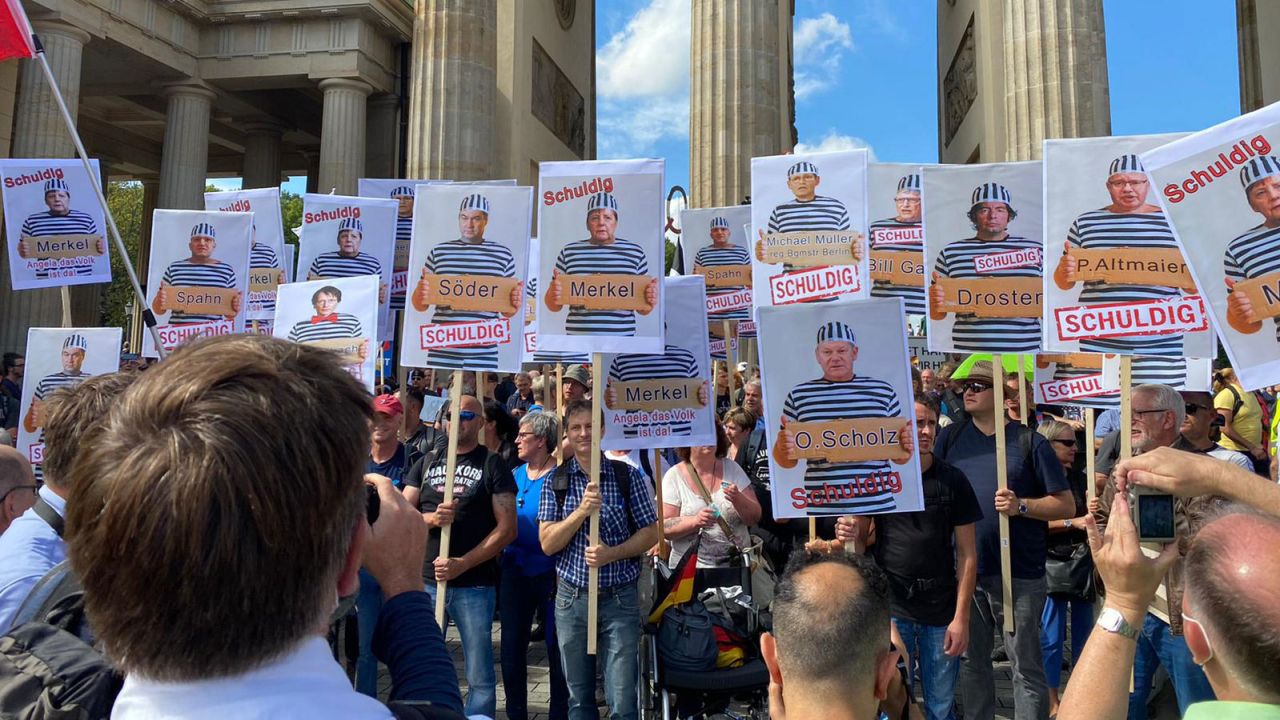Some held up signs showing pictures of German lawmakers and the word "guilty."